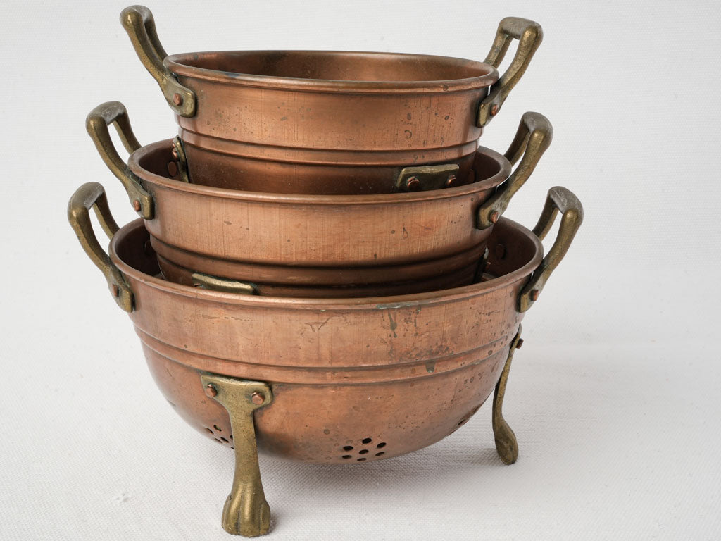 Sculpturally delightful copper colander duo
