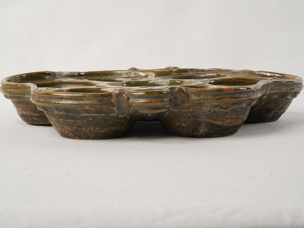 Aged dark brown cocotte vessel.