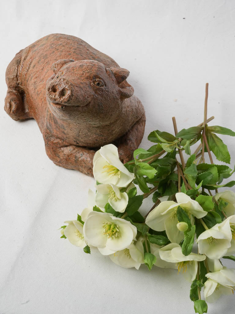 Weathered terracotta-toned pig sculpture