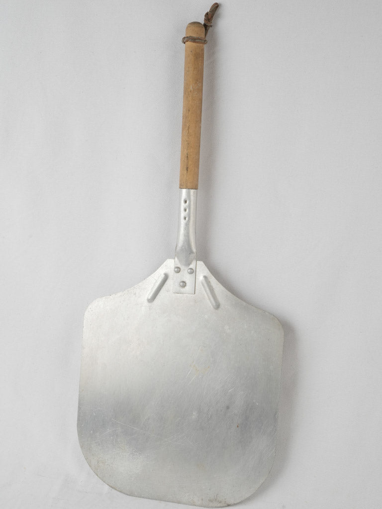 Aged metal pizza peel with wood handle
