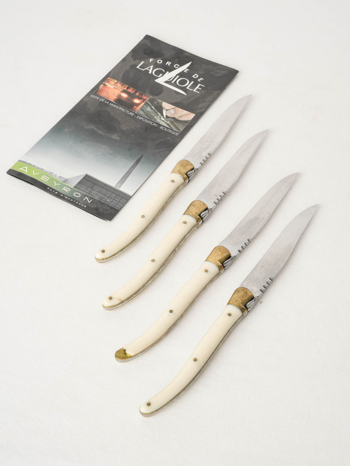Set of four vintage Forge de Laguiole knives with white handles