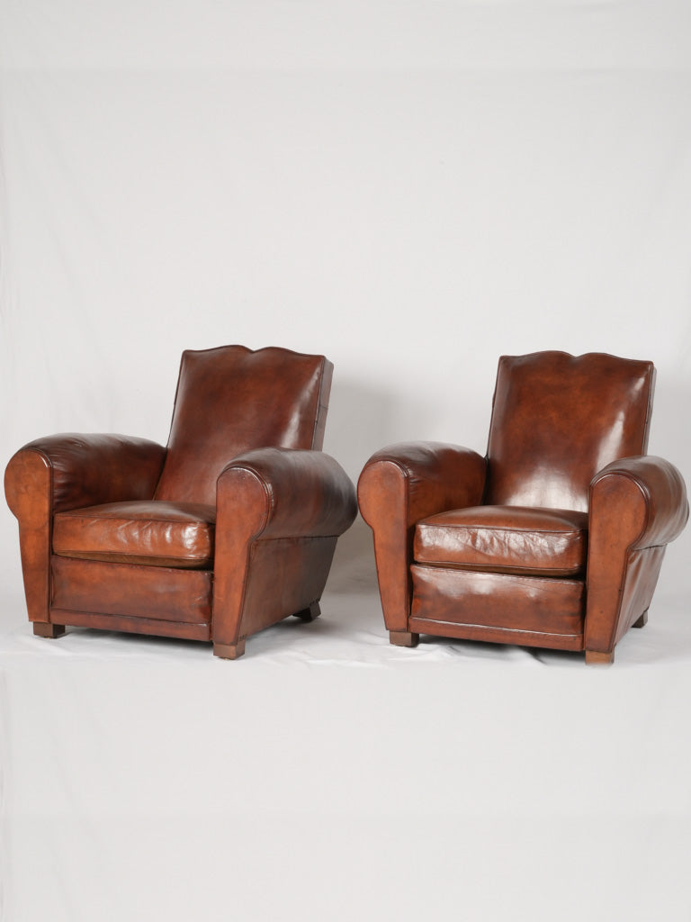Pair of antique French leather club chairs moustache back
