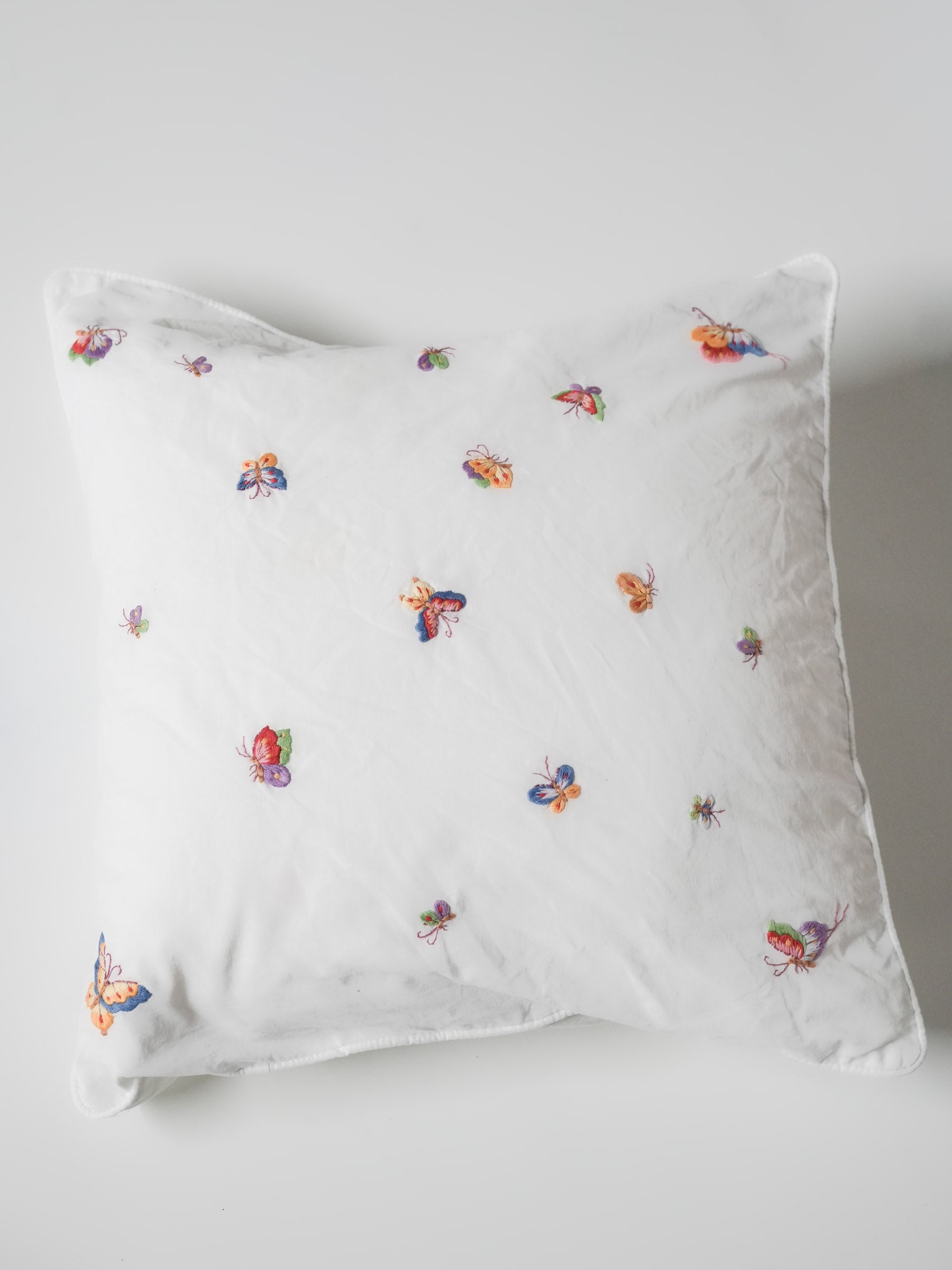 White pillowcase embroidered with colorful butterflies