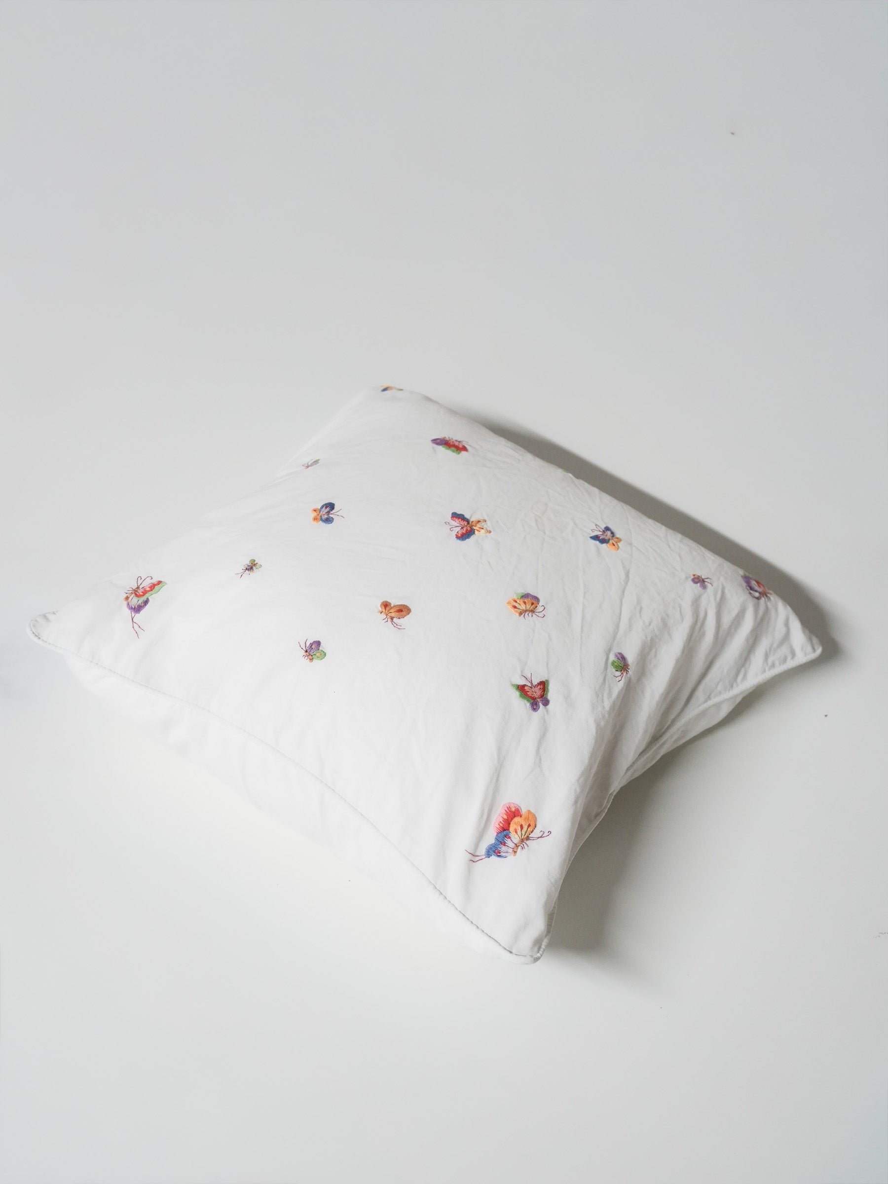 White pillowcase embroidered with colorful butterflies