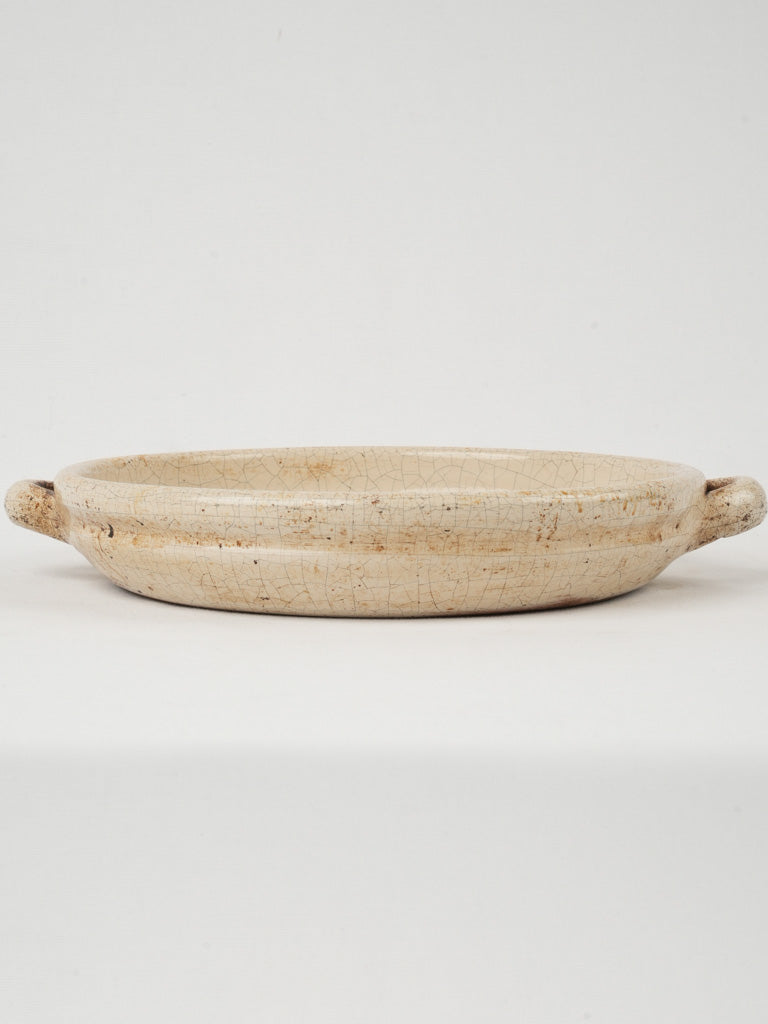 Antique cream-colored pottery baking dish