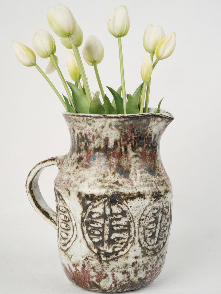 Textured ceramic pitcher with foliage