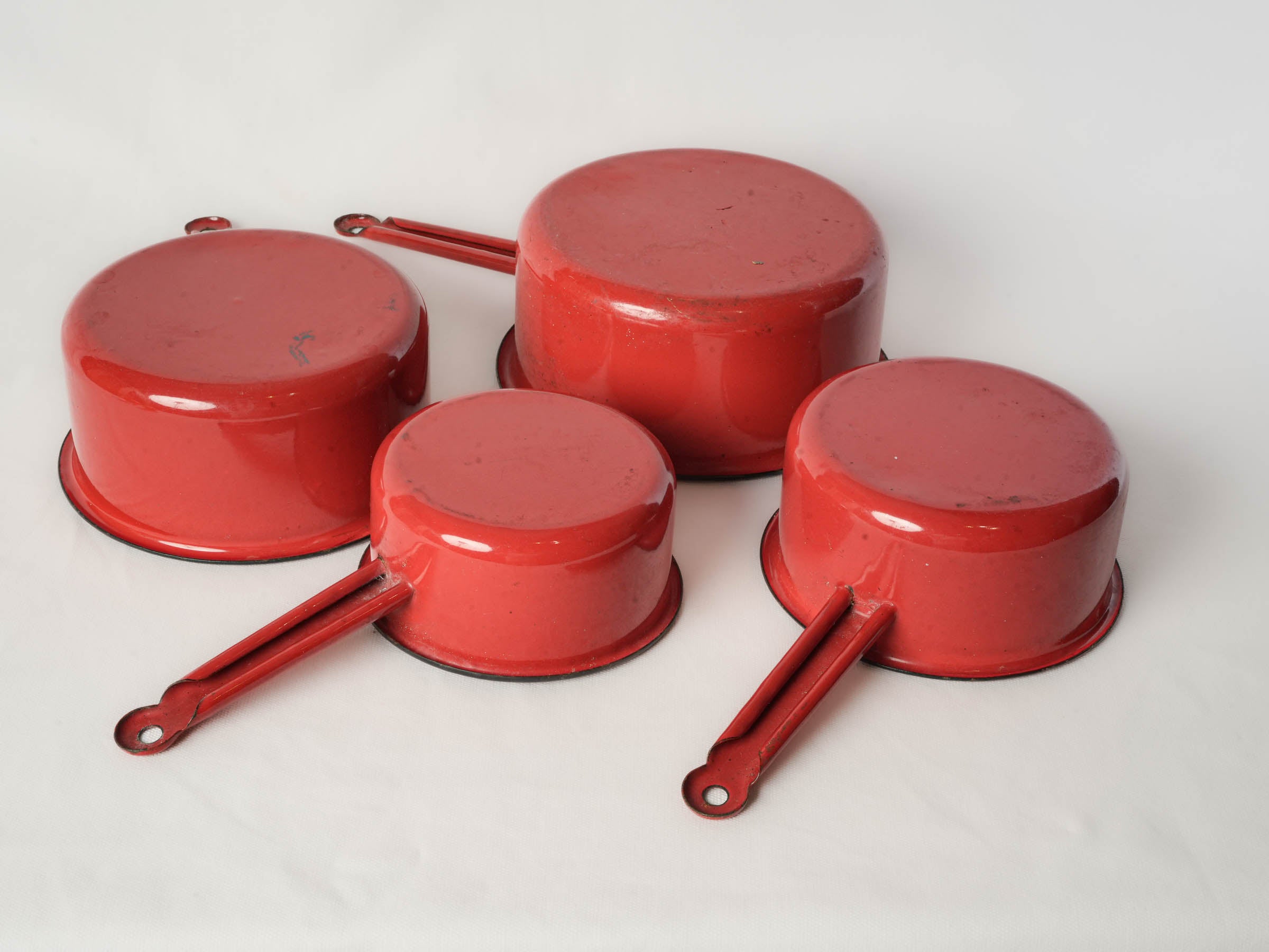 Set of Four Graduated Red Enamel Saucepans