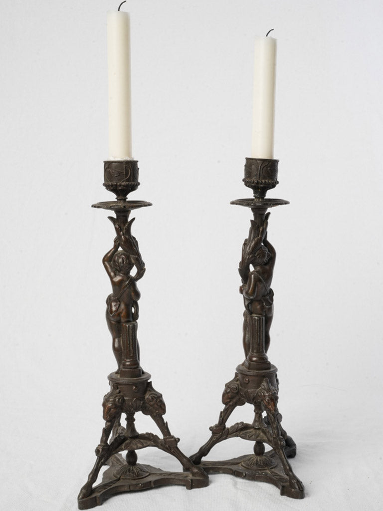 Cherub-decorated tripod base candlesticks