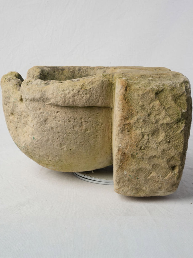 Weathered buff limestone wall fountain