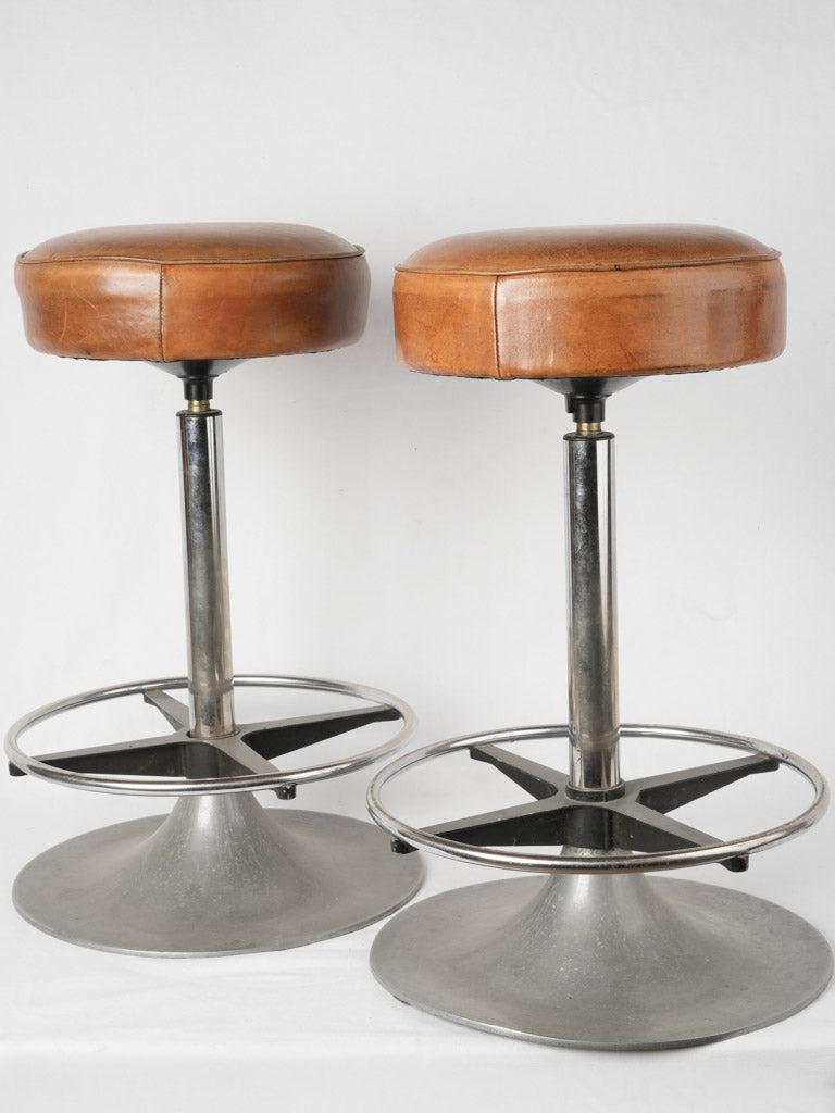 Weathered brown leather barstool pair