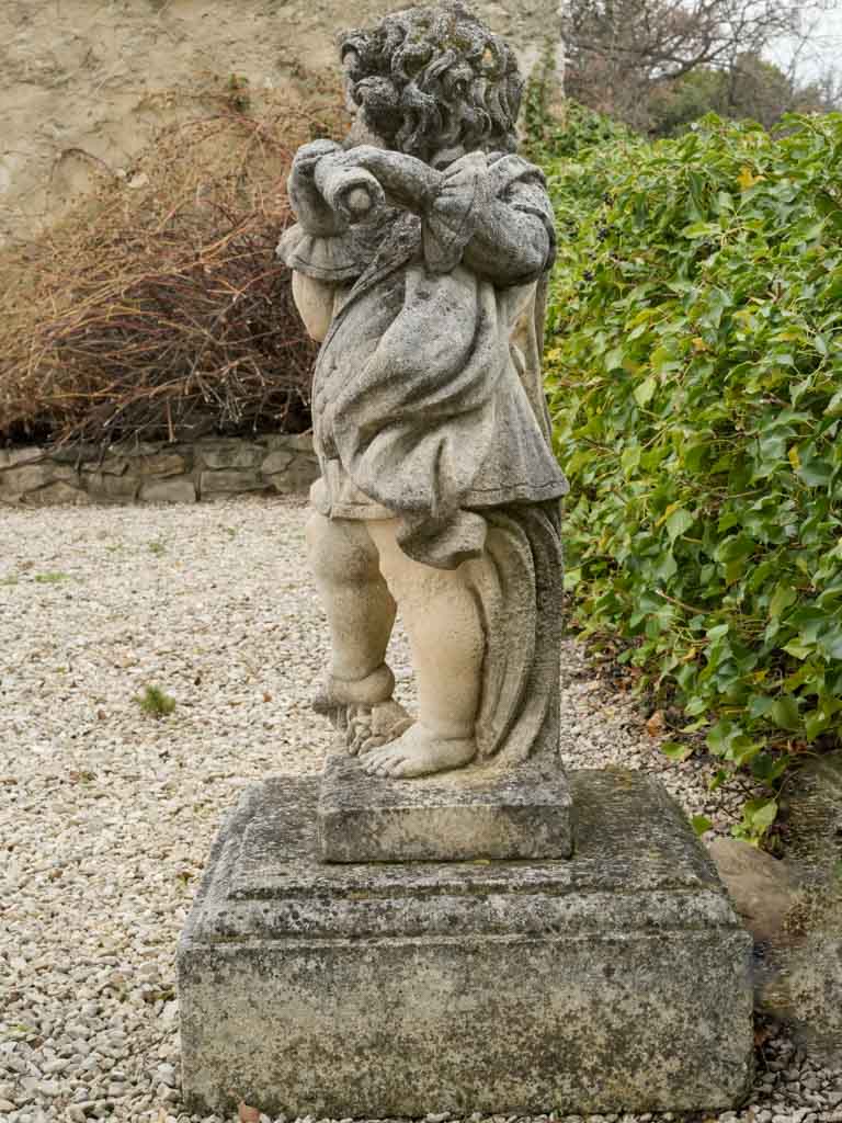 Vintage stone flute-playing cherub figure