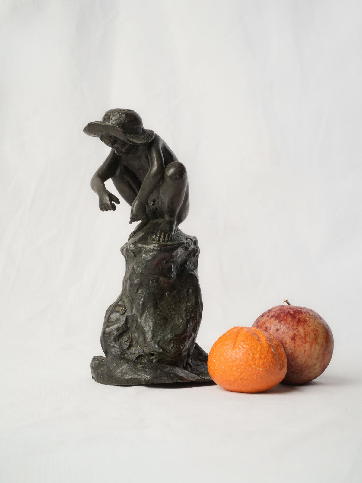 Charming Petite Black-Patinated Bronze Figure of a Crouching Boy on a Rocky Outcrop - 9½"