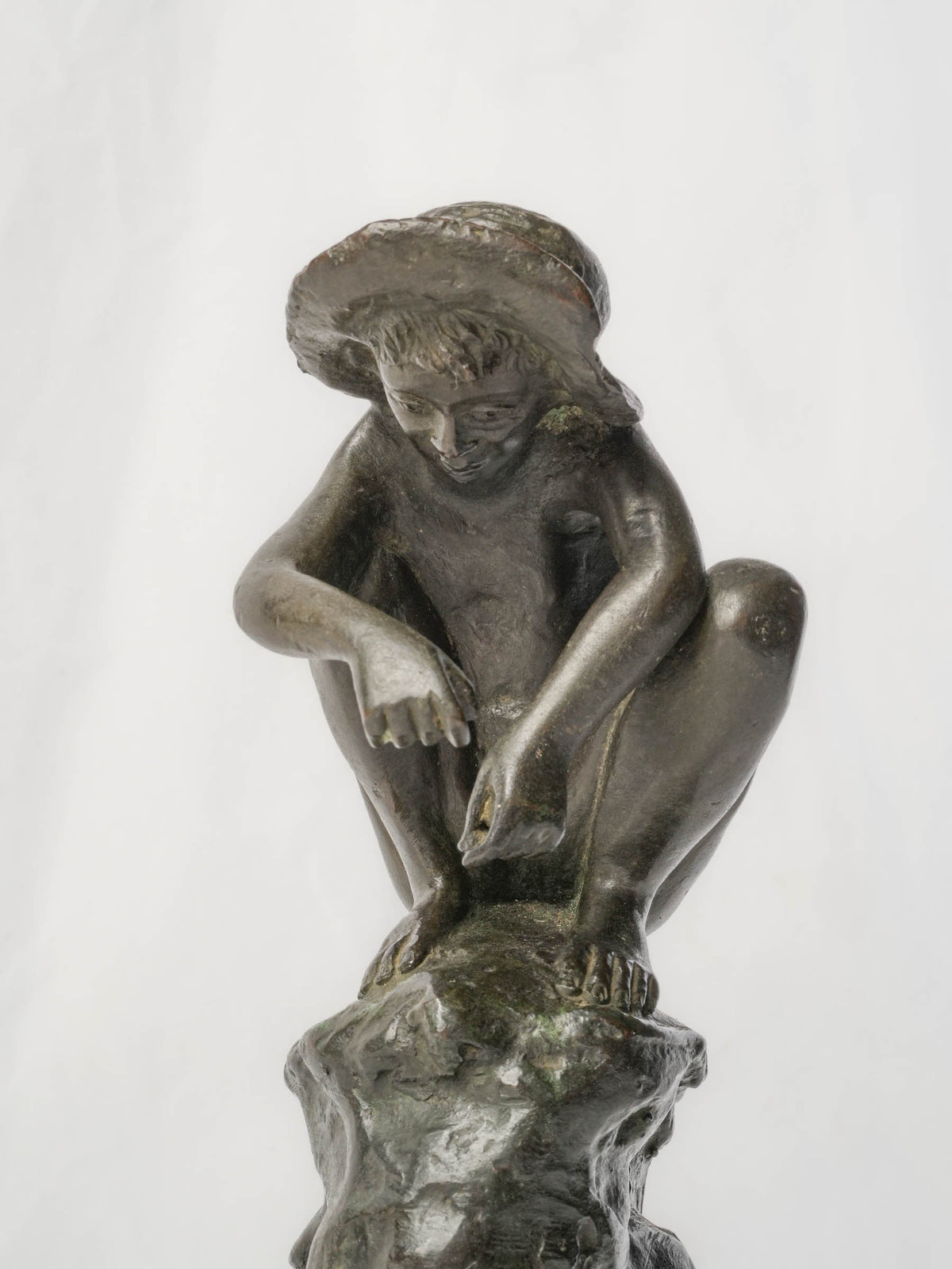 Charming Petite Black-Patinated Bronze Figure of a Crouching Boy on a Rocky Outcrop - 9½"