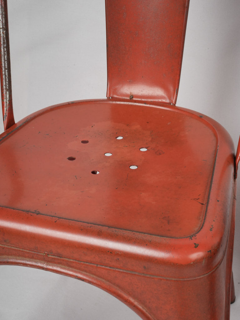 Patina-enhanced red Tolix chairs