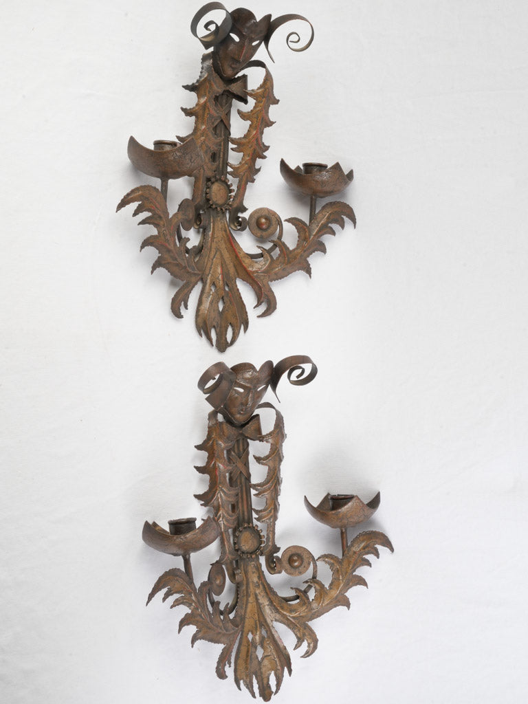 Patina rich theatrical mask sconces