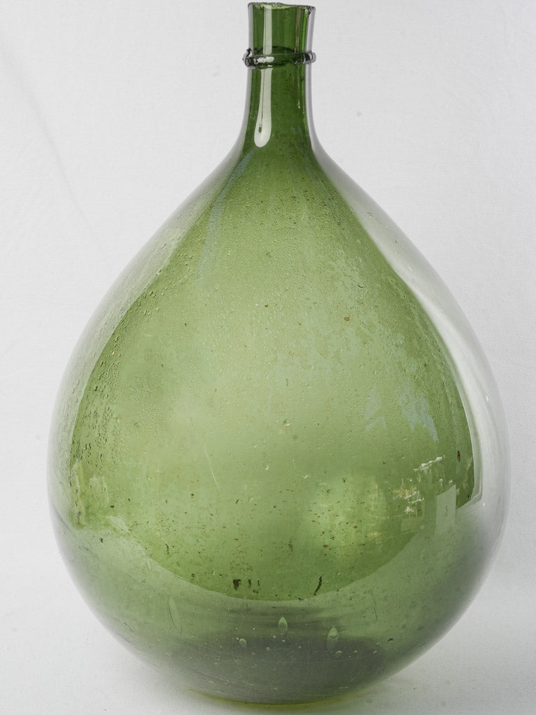 Antique verdant demijohn glass bottle