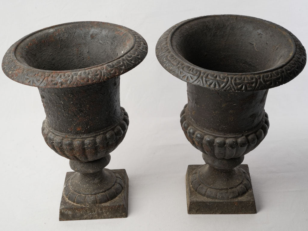 Charming timeworn cast iron urns