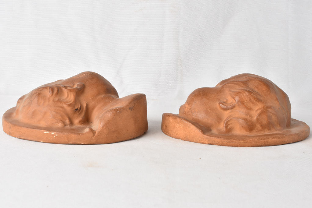 Slightly weathered cherub face sculptures