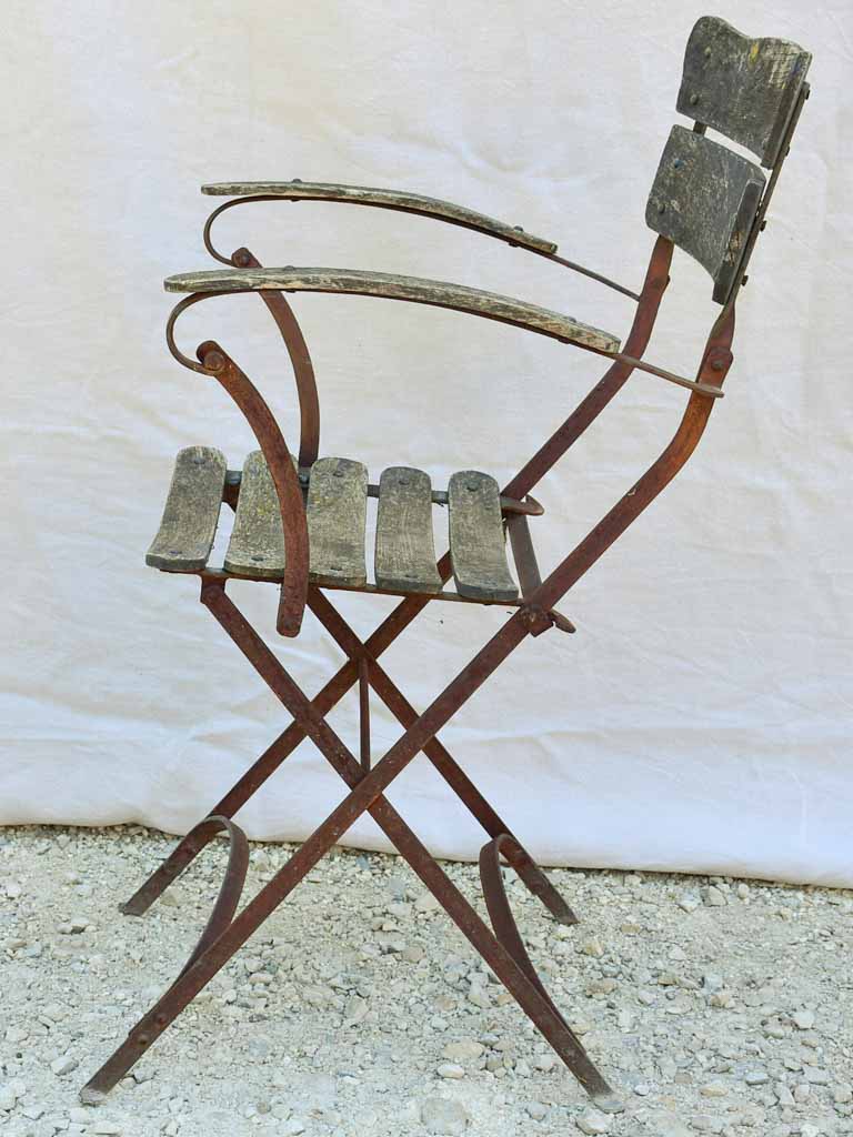 Four antique French iron and timber slatted garden armchairs