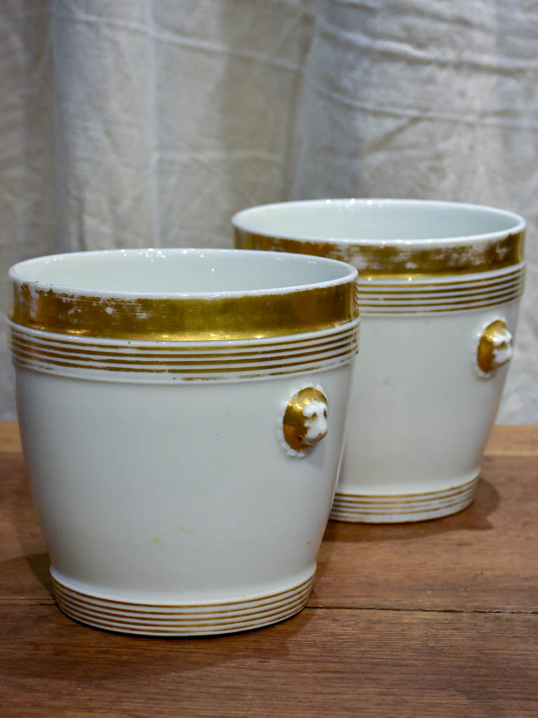 Pair of antique French porcelain pot stands with gold lion's heads