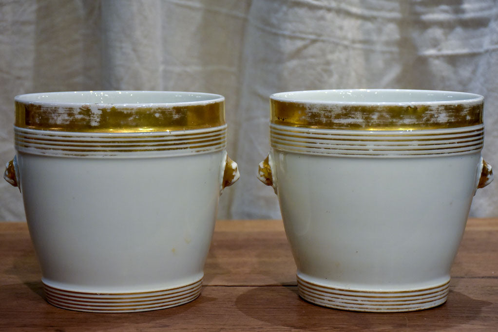 Pair of antique French porcelain pot stands with gold lion's heads