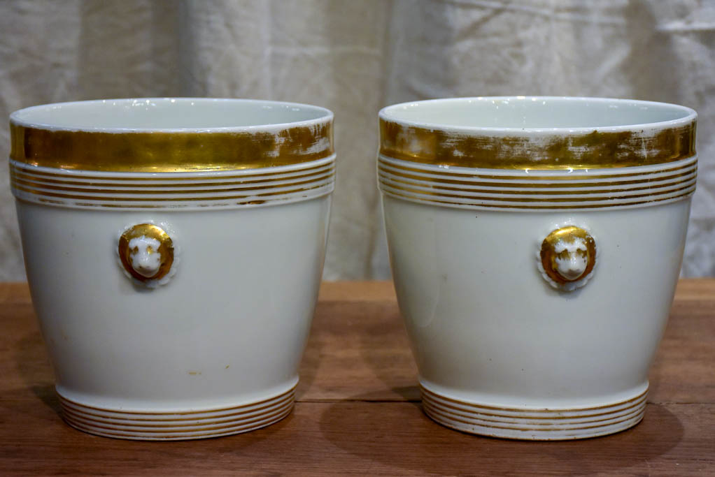 Pair of antique French porcelain pot stands with gold lion's heads