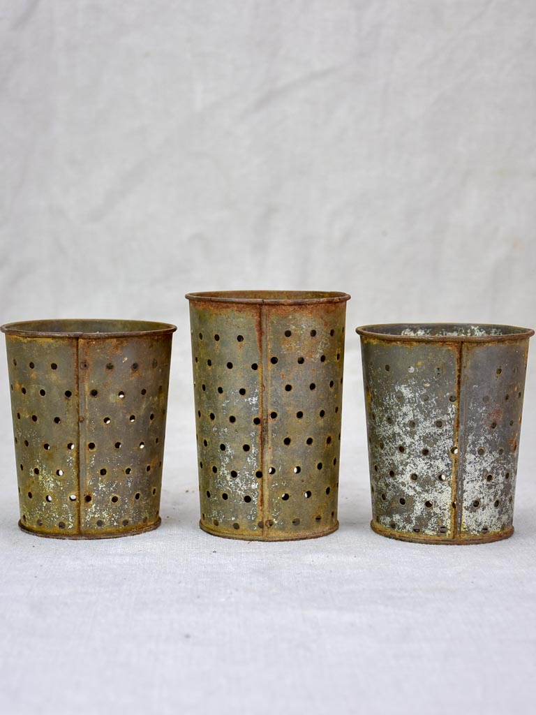 Collection of three tin cheese strainer molds / faisselles