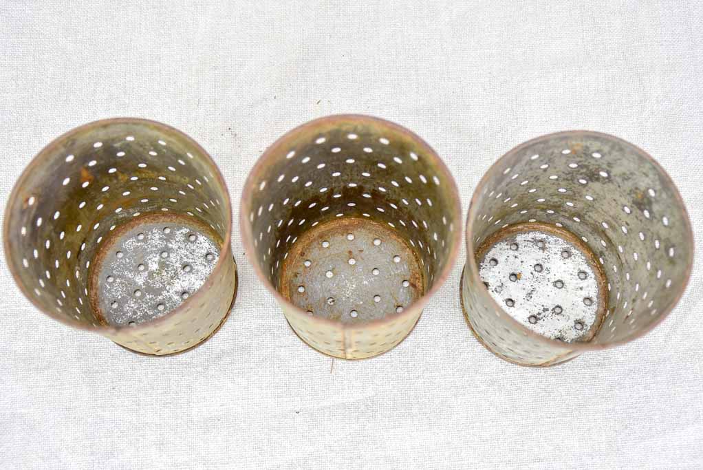 Collection of three tin cheese strainer molds / faisselles