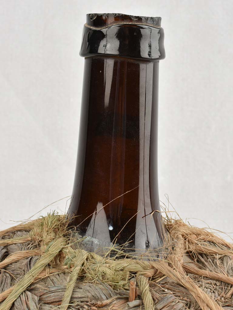 Small demijohn bottle in woven straw basket 13½"