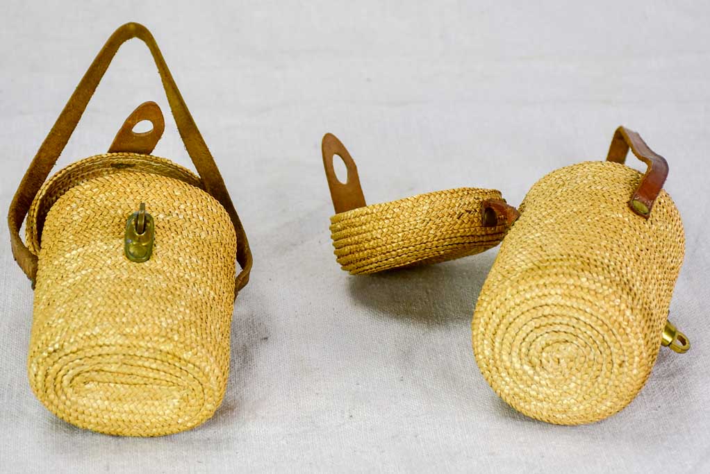 Two mid century French 'verre de cure' glasses in baskets