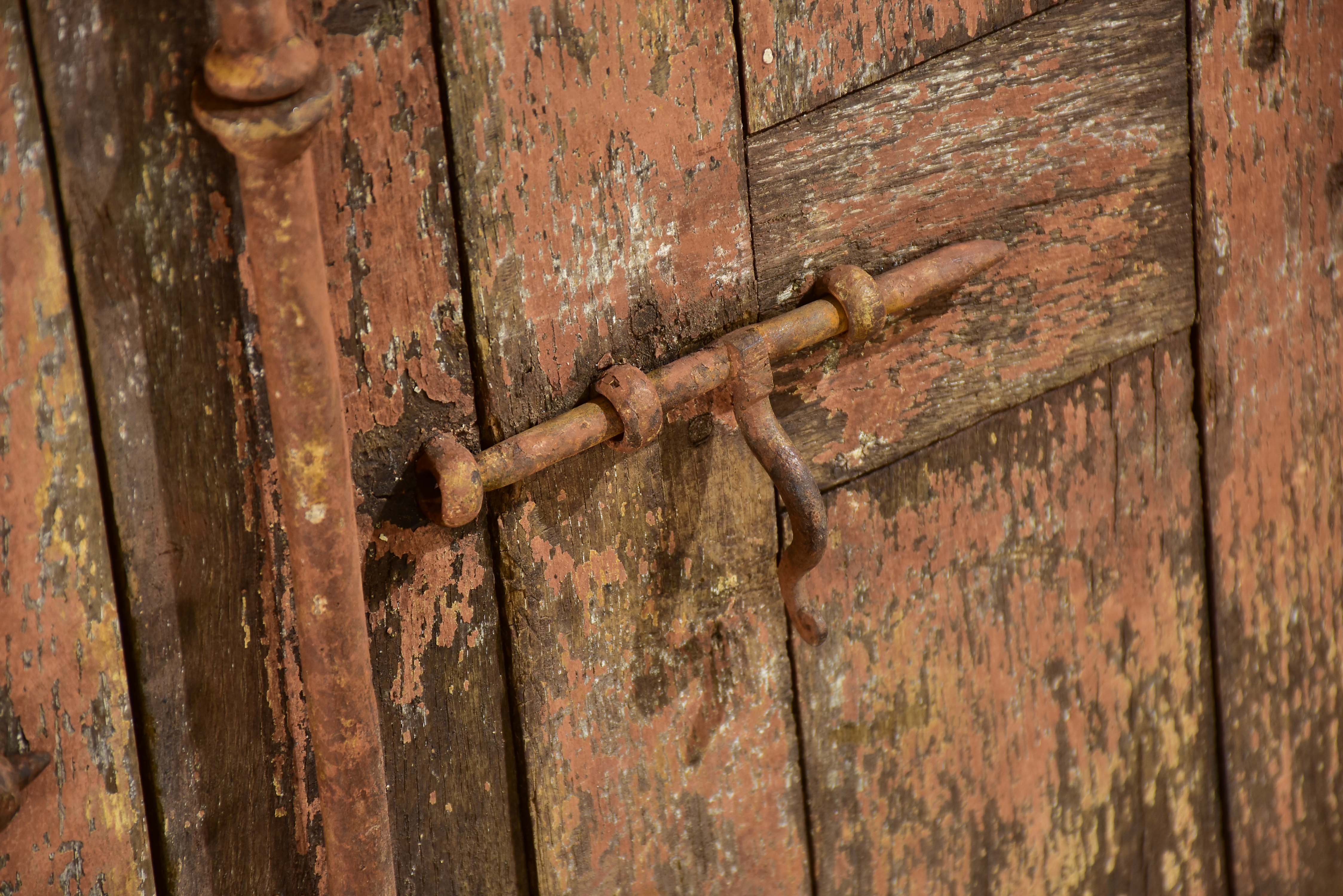 Pair of antique French shutters with original hardware and red patina