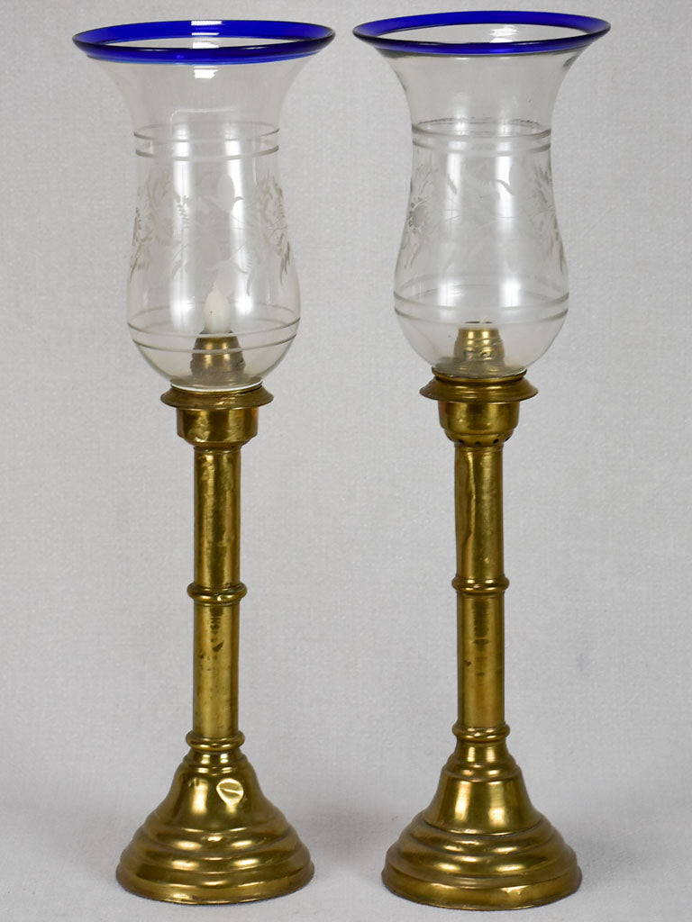 Pair of candleholders on brass stands with blown glass hurricane