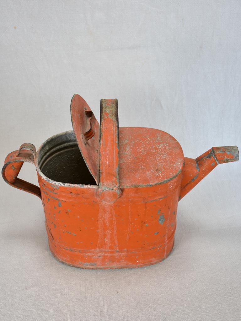Antique French covered watering can with red patina