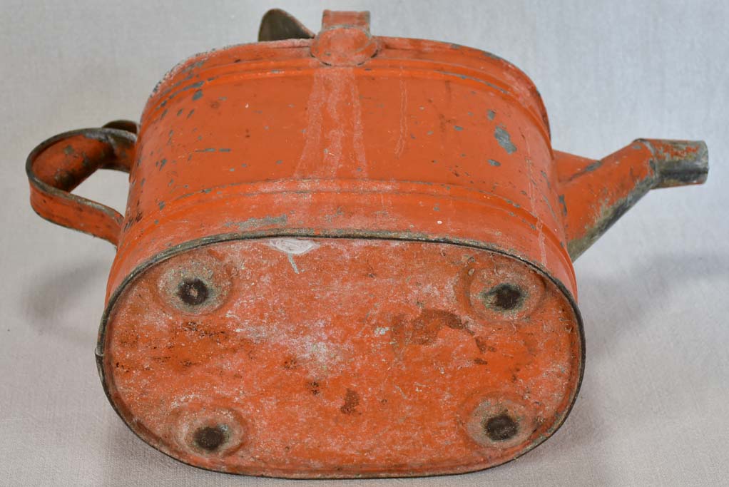 Antique French covered watering can with red patina