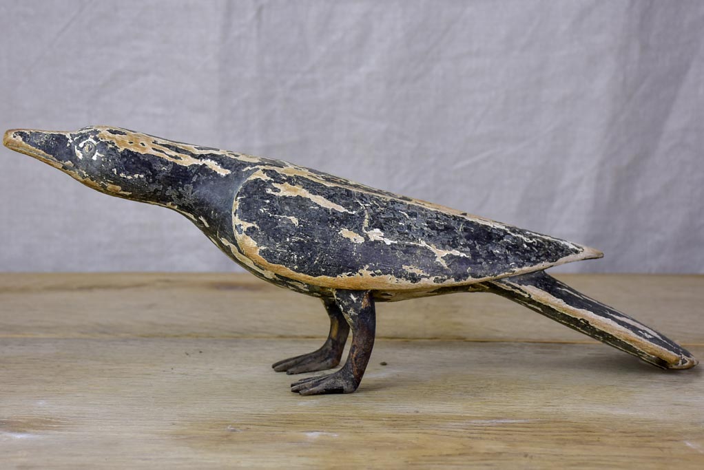 Rustic wooden sculpture of a raven - folk art