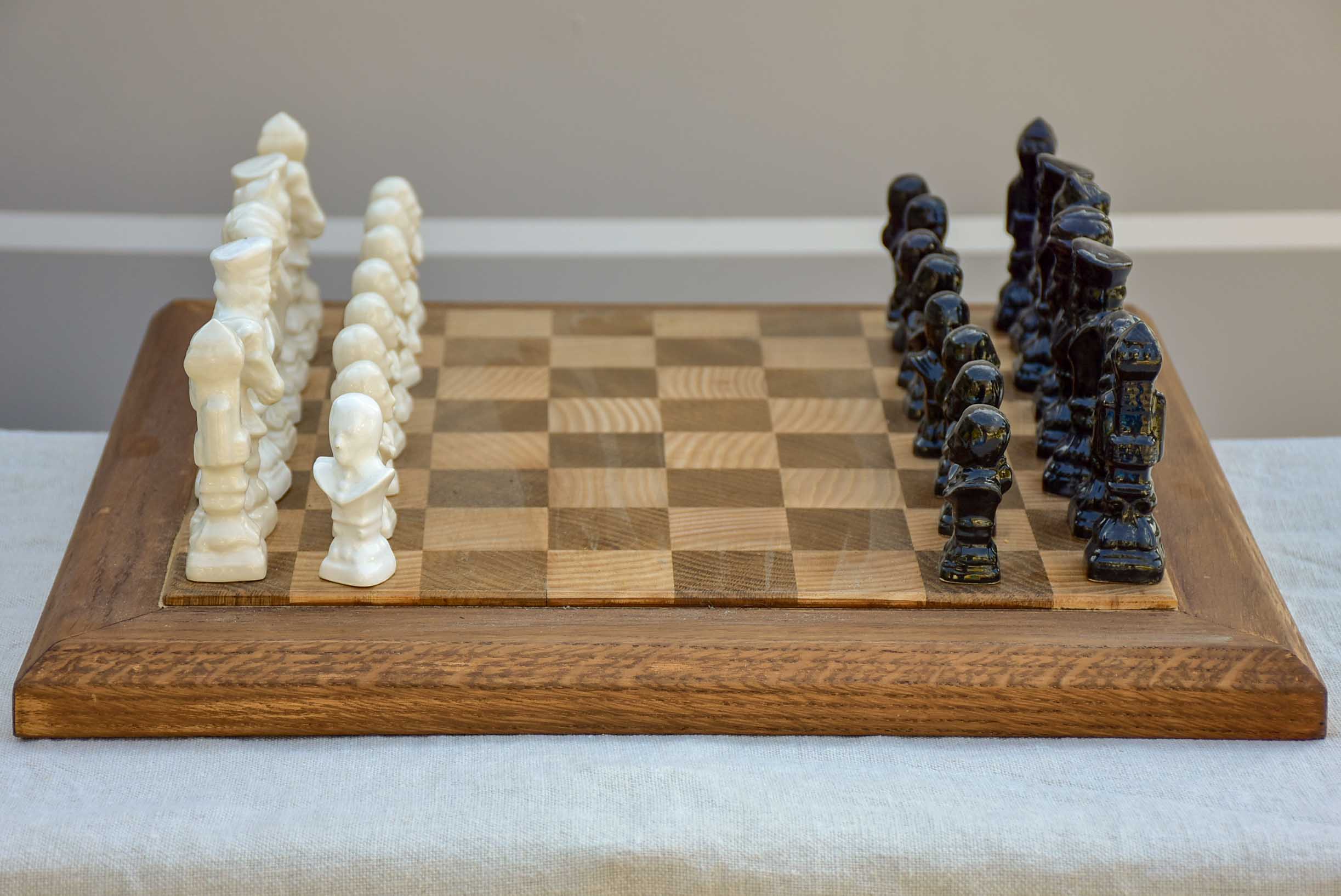 Vintage wooden chess board with porcelain pieces