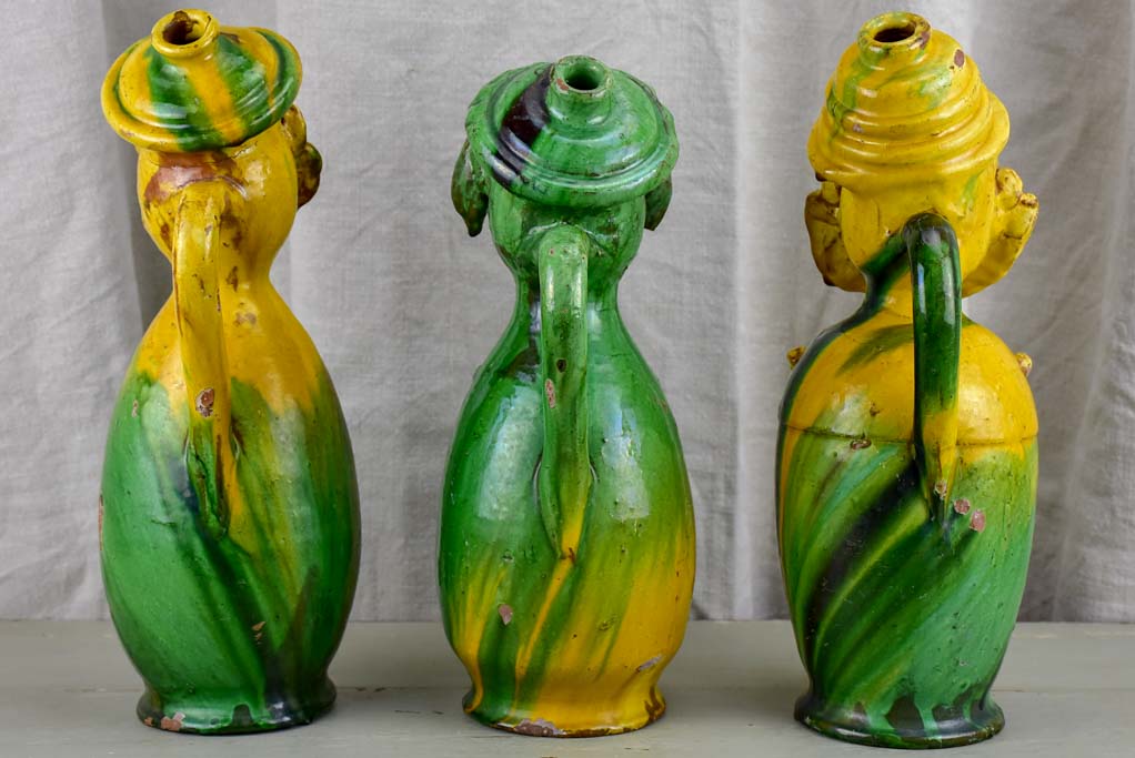 Three antique folk art pitchers with yellow and green glaze