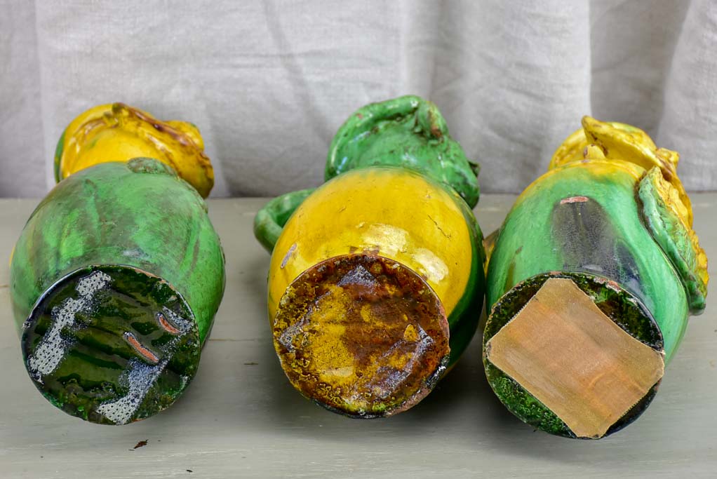 Three antique folk art pitchers with yellow and green glaze