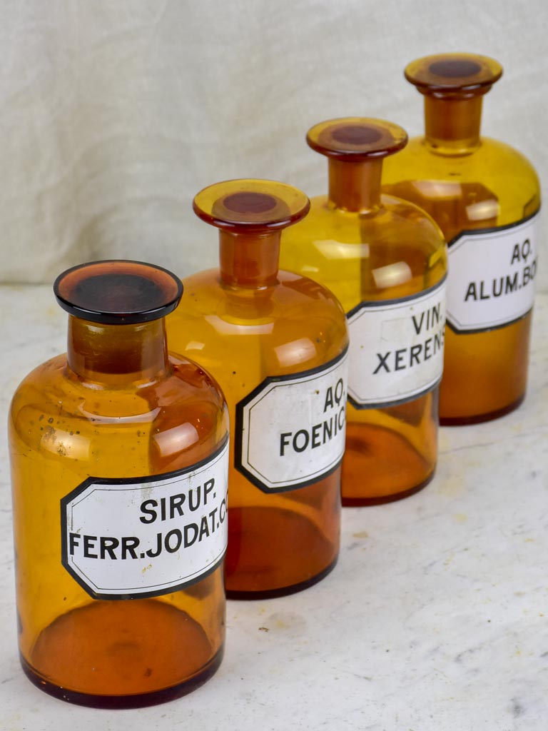 Four antique French apothecary jars with original glass lids - amber