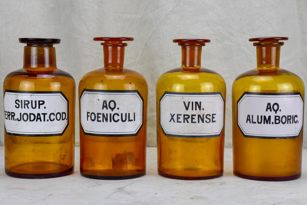 Four antique French apothecary jars with original glass lids - amber