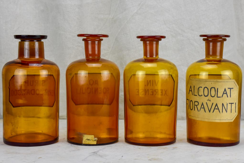 Four antique French apothecary jars with original glass lids - amber