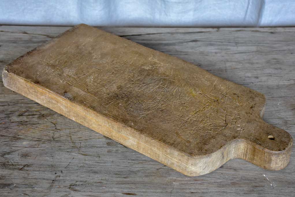 Large antique French cutting board with rounded handle and shoulders