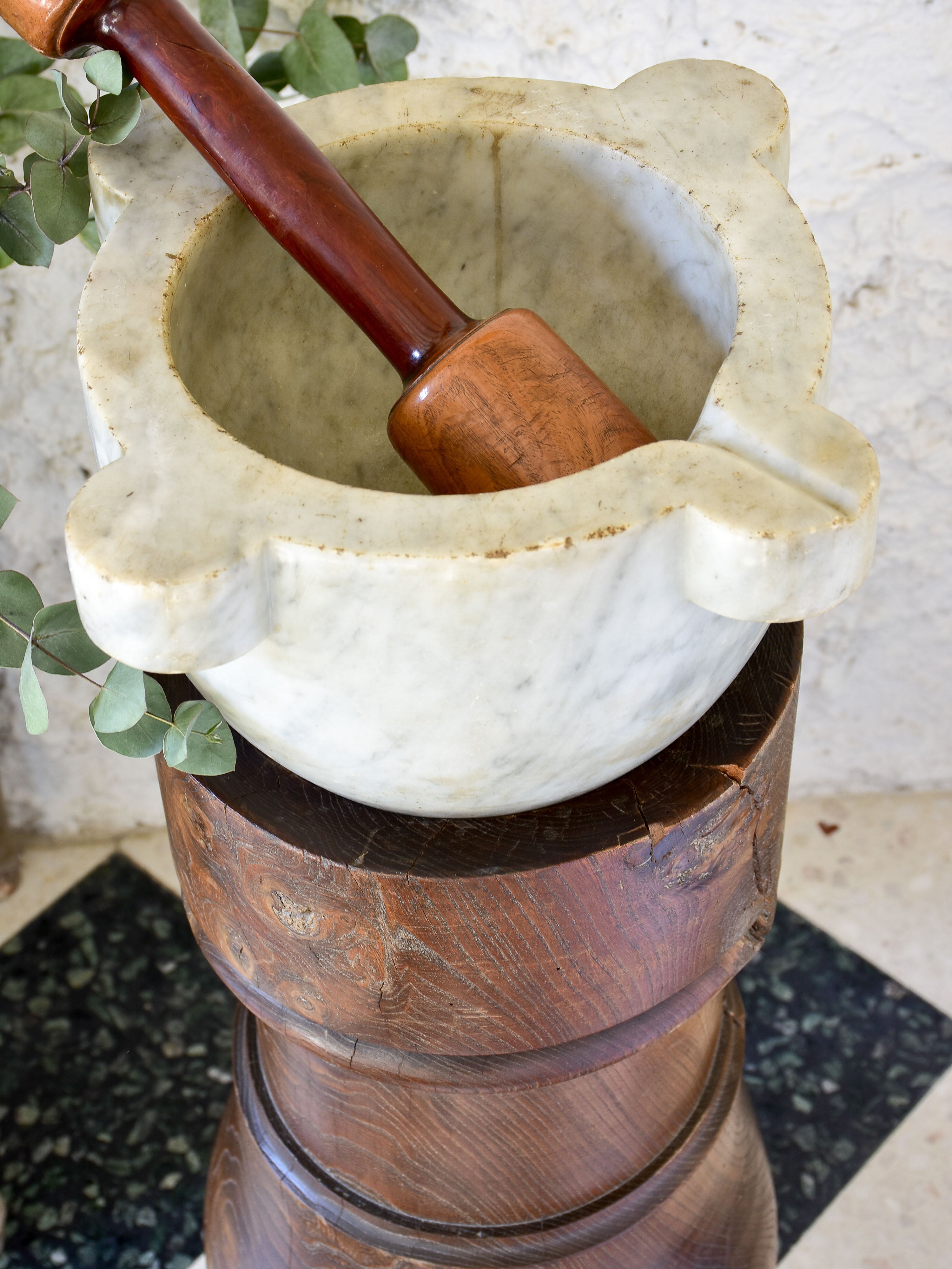 Marble mortar with double headed pestle in carved timber stand
