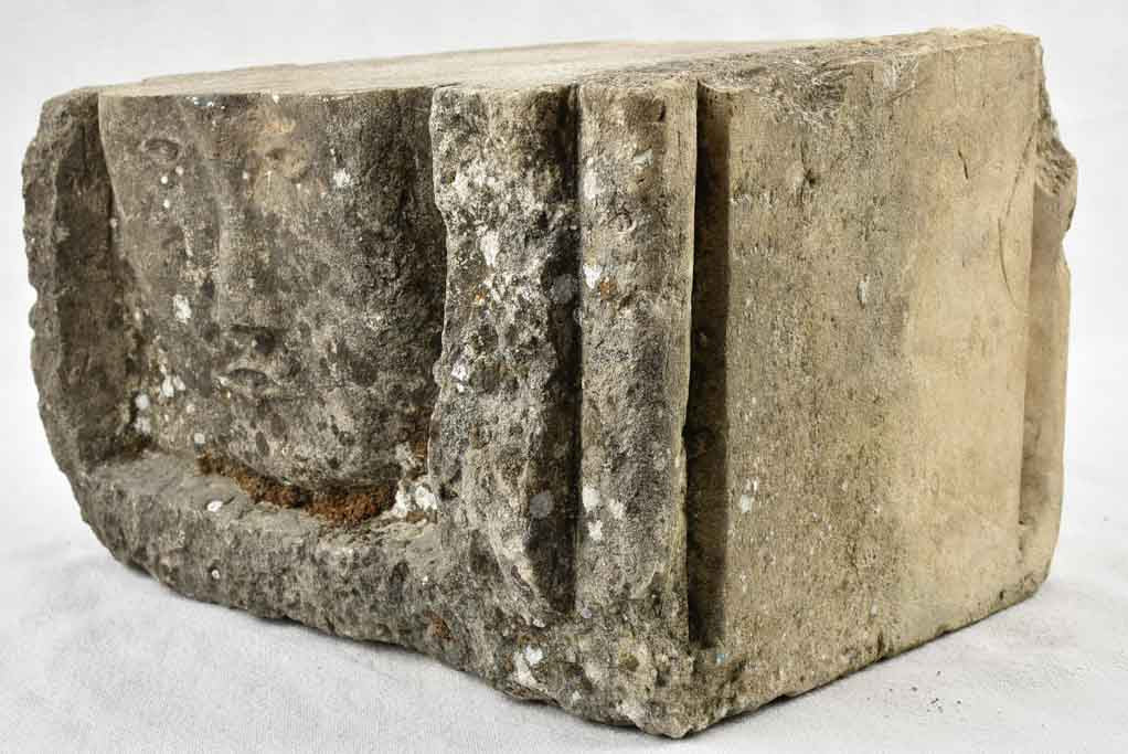 Old hand-carved stone face decoration