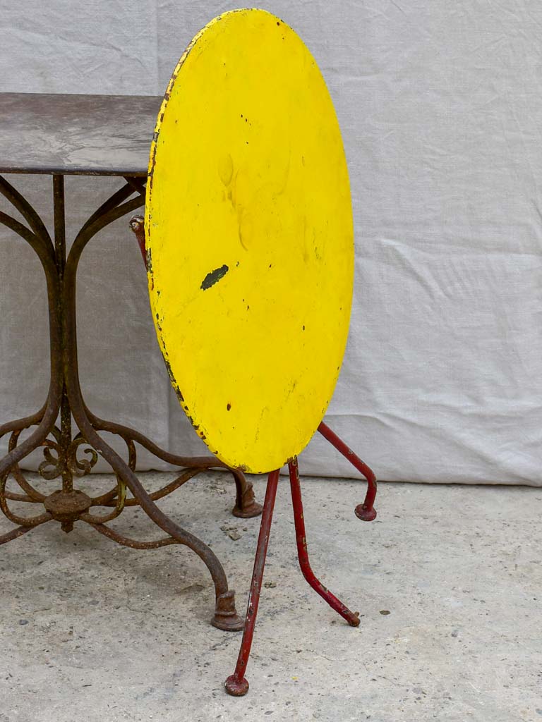 Folding antique French garden table with yellow table top and red legs