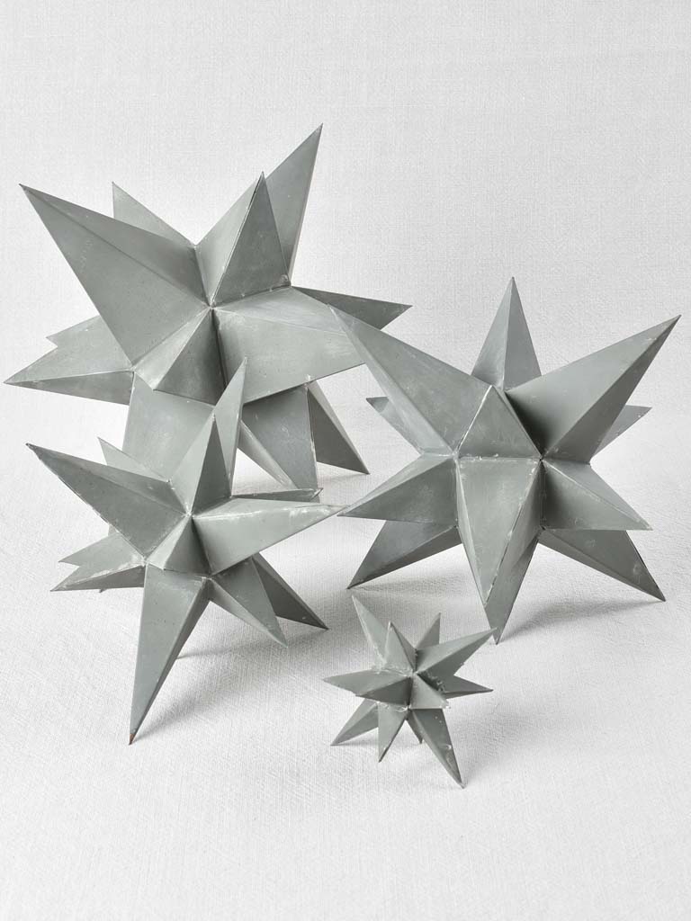 Collection of four early 20th century zinc stars 3½" - 10¼"
