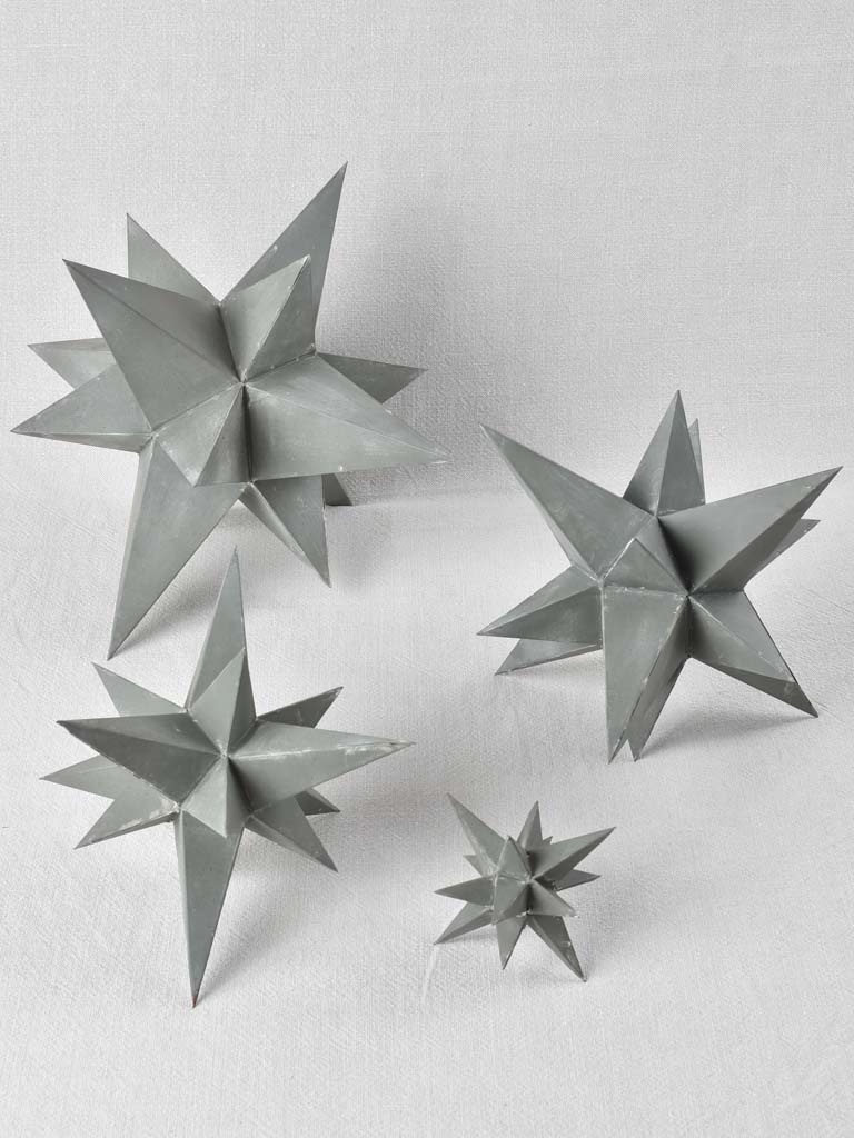Collection of four early 20th century zinc stars 3½" - 10¼"