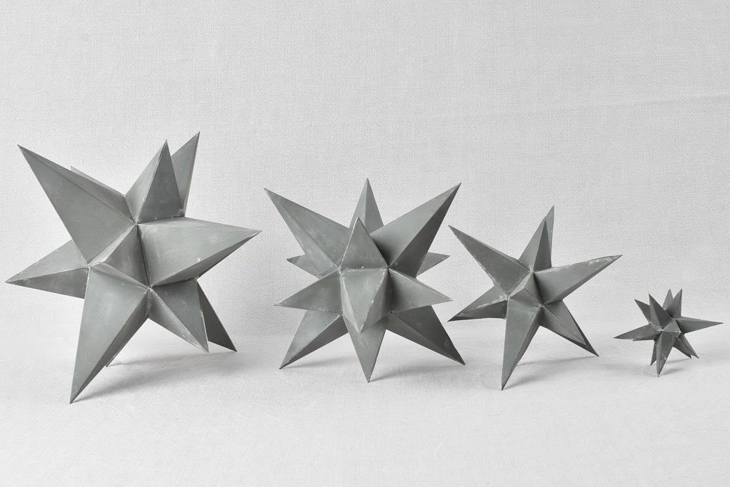 Collection of four early 20th century zinc stars 3½" - 10¼"