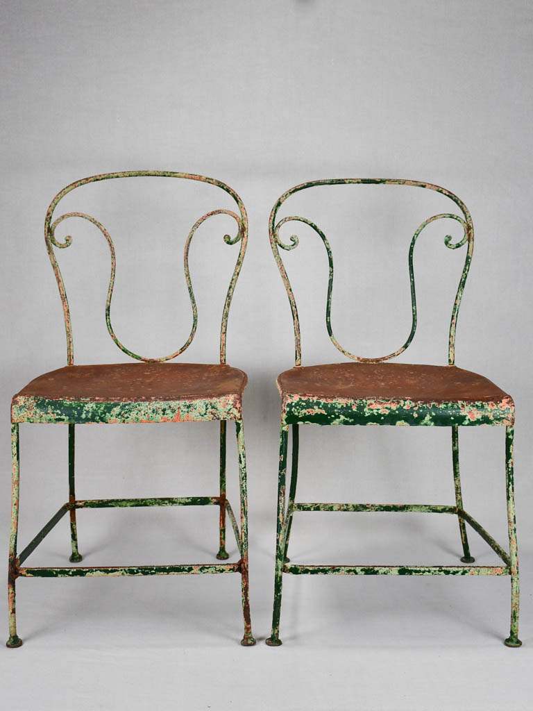 Pair of rustic French garden chairs with green patina