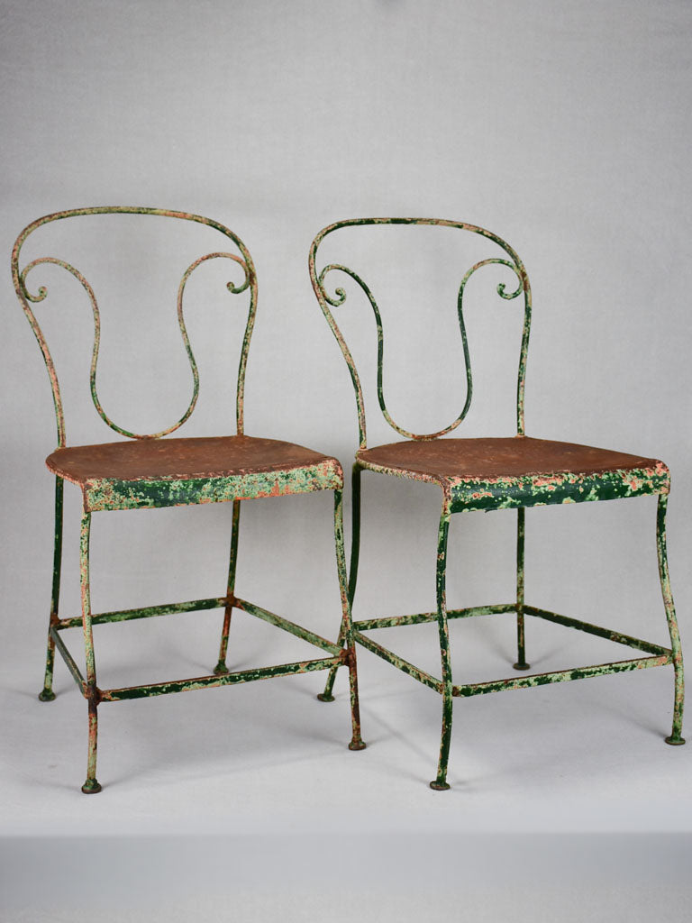 Pair of rustic French garden chairs with green patina